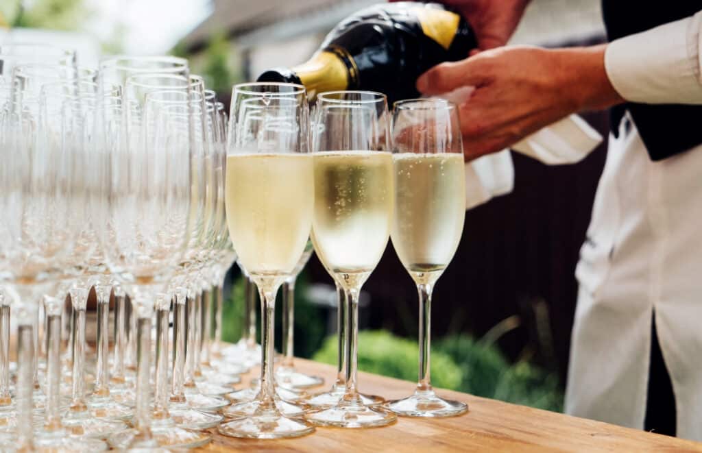 waiter pouring glasses of champagne