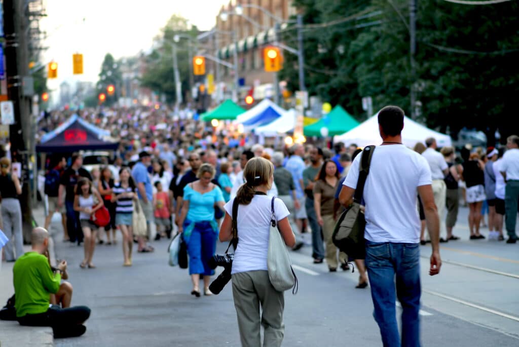 A couple of photographers heading into a crowd at nonprofit charity street festival