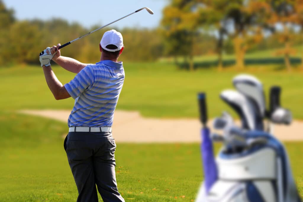 Man swinging a golf club at a golf tournament