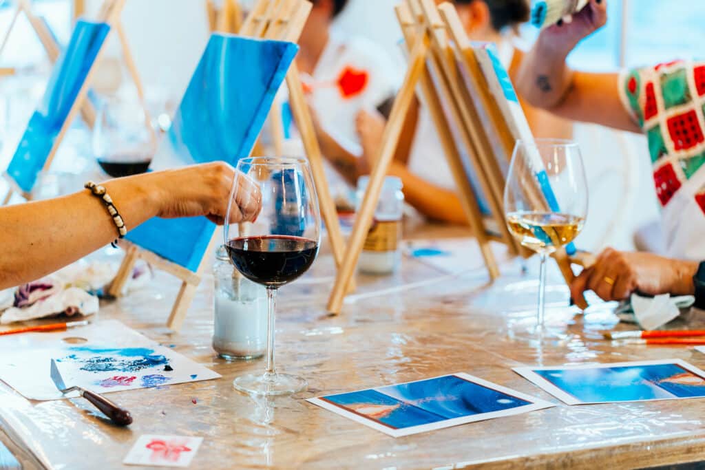 Sip and Paint Event with Women Creating Art over Wine Glasses