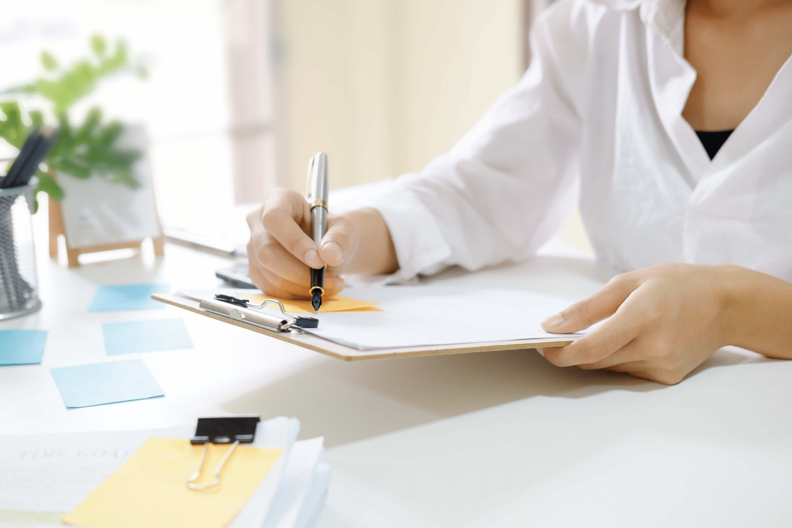 a girl writing event budget expenses on a clipboard