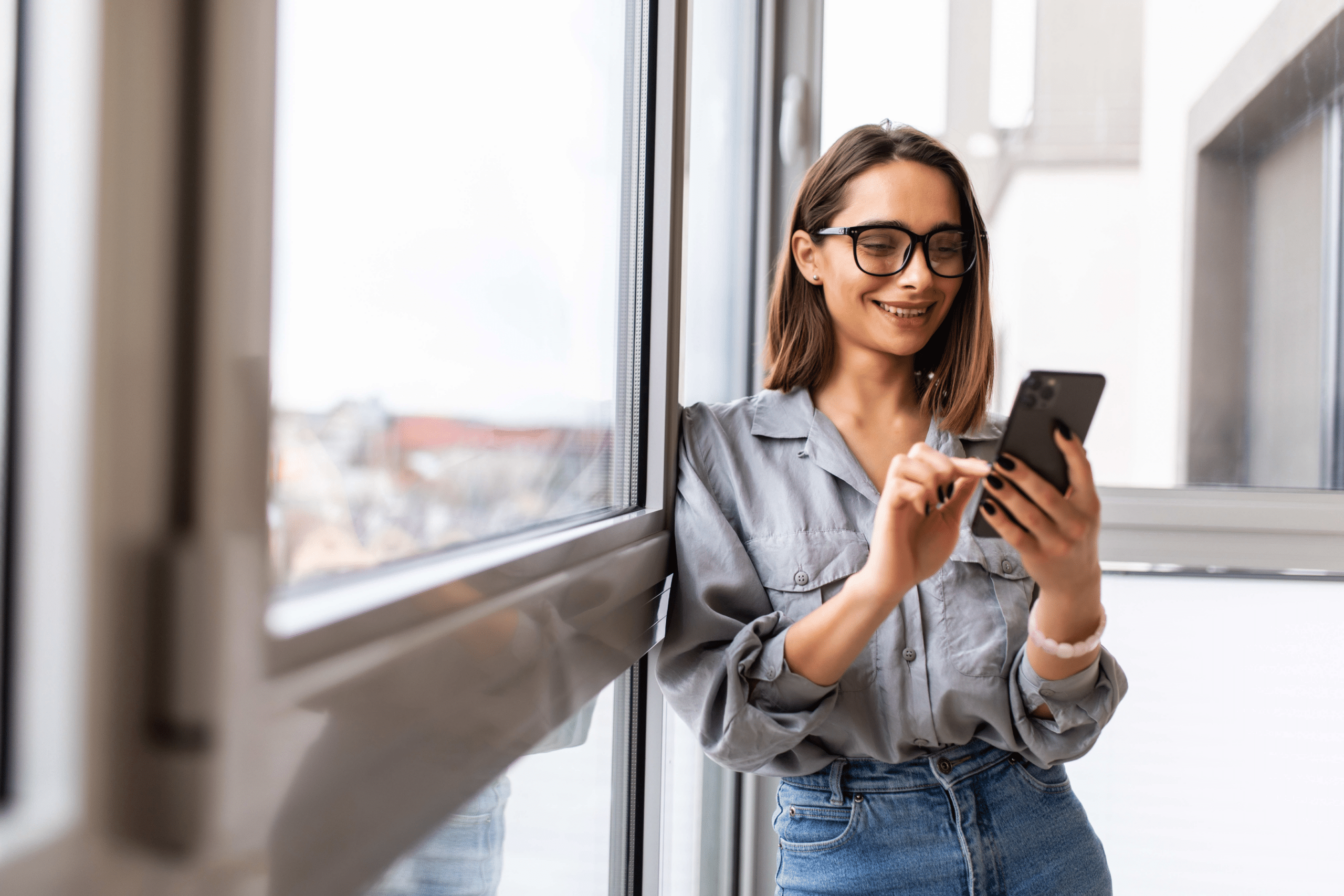 a girl smiling while looking at her phone