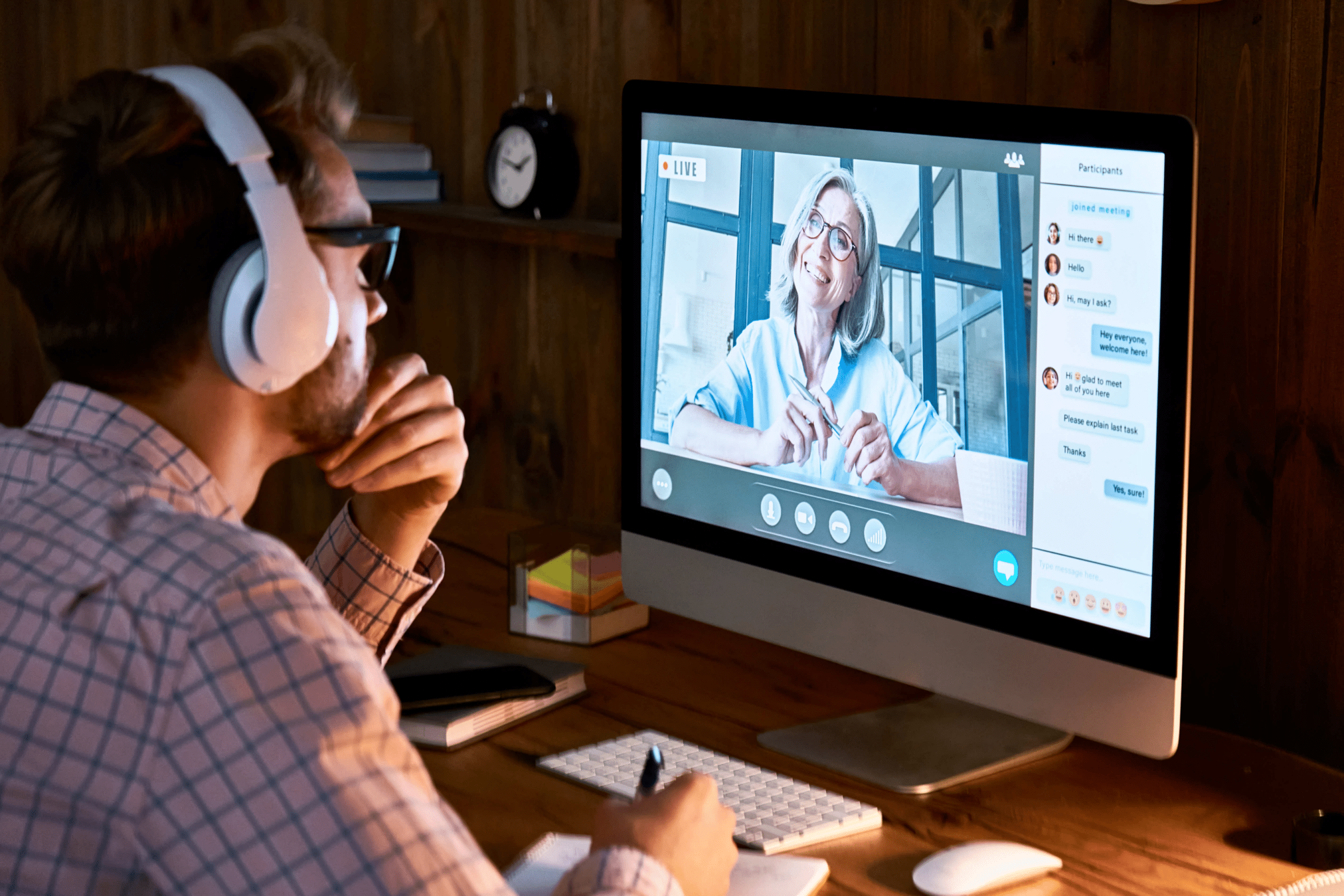 a man with white headphones on taking an online webinar class