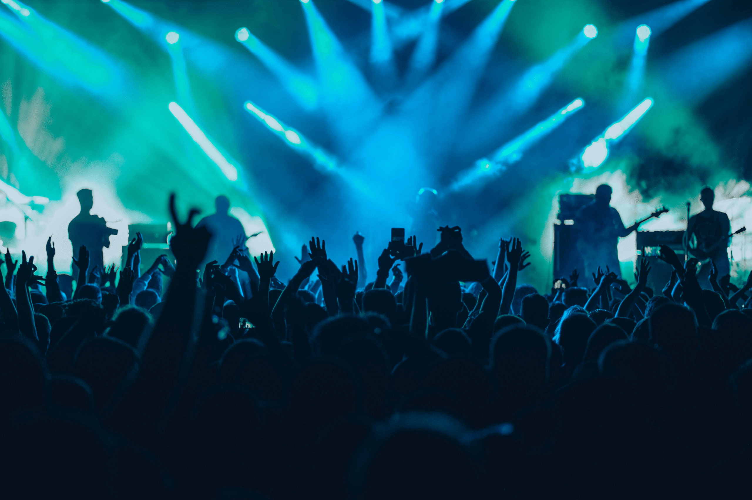 sold out rock concert with blue and green stage lights