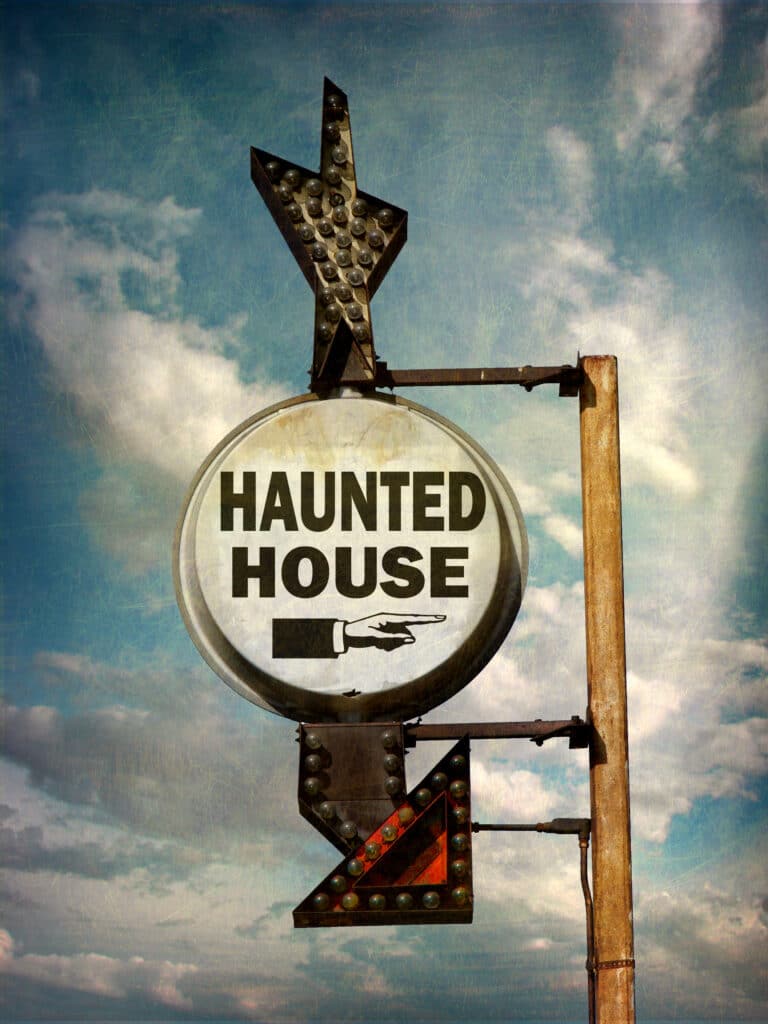 a haunted house sign pointing to the venue 