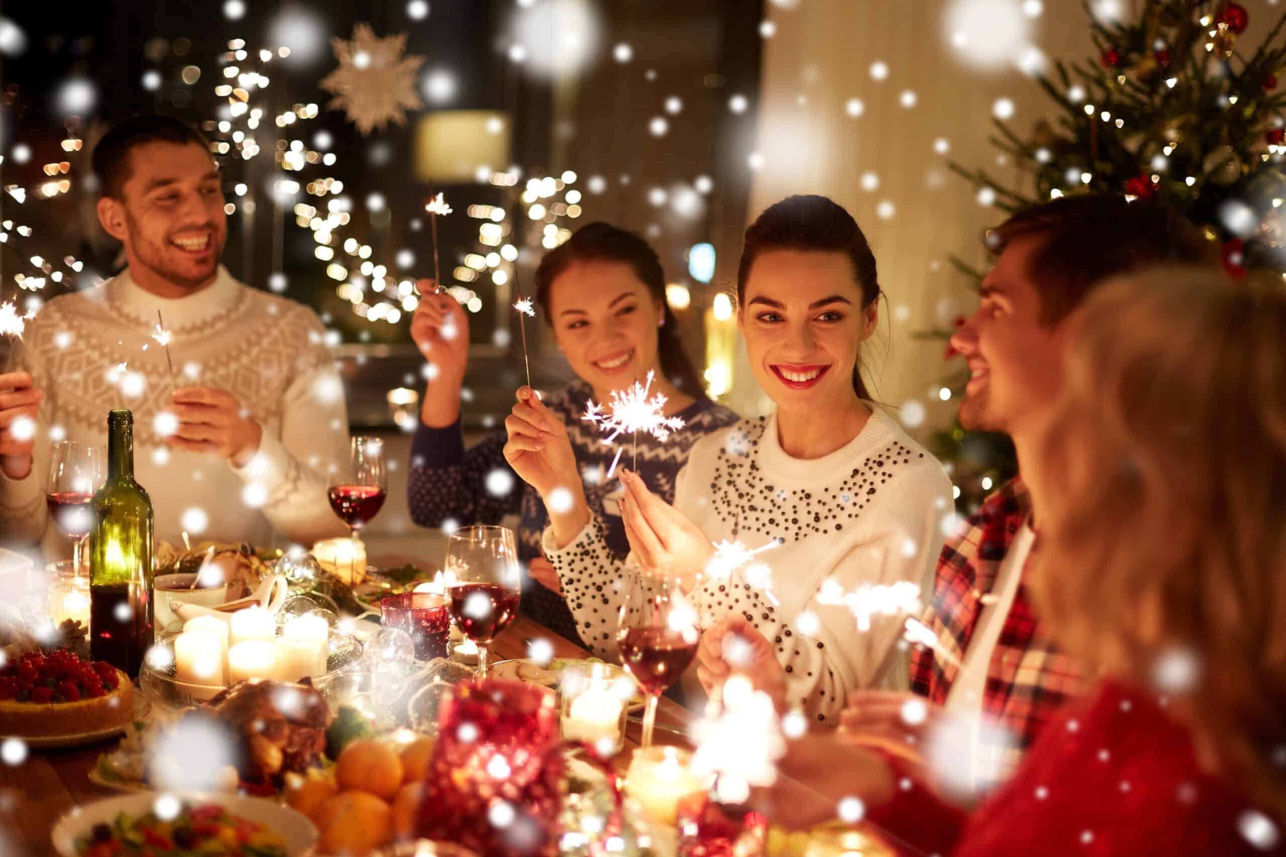 A group of friends at a winter wonderland themed dinner holding sparklers 