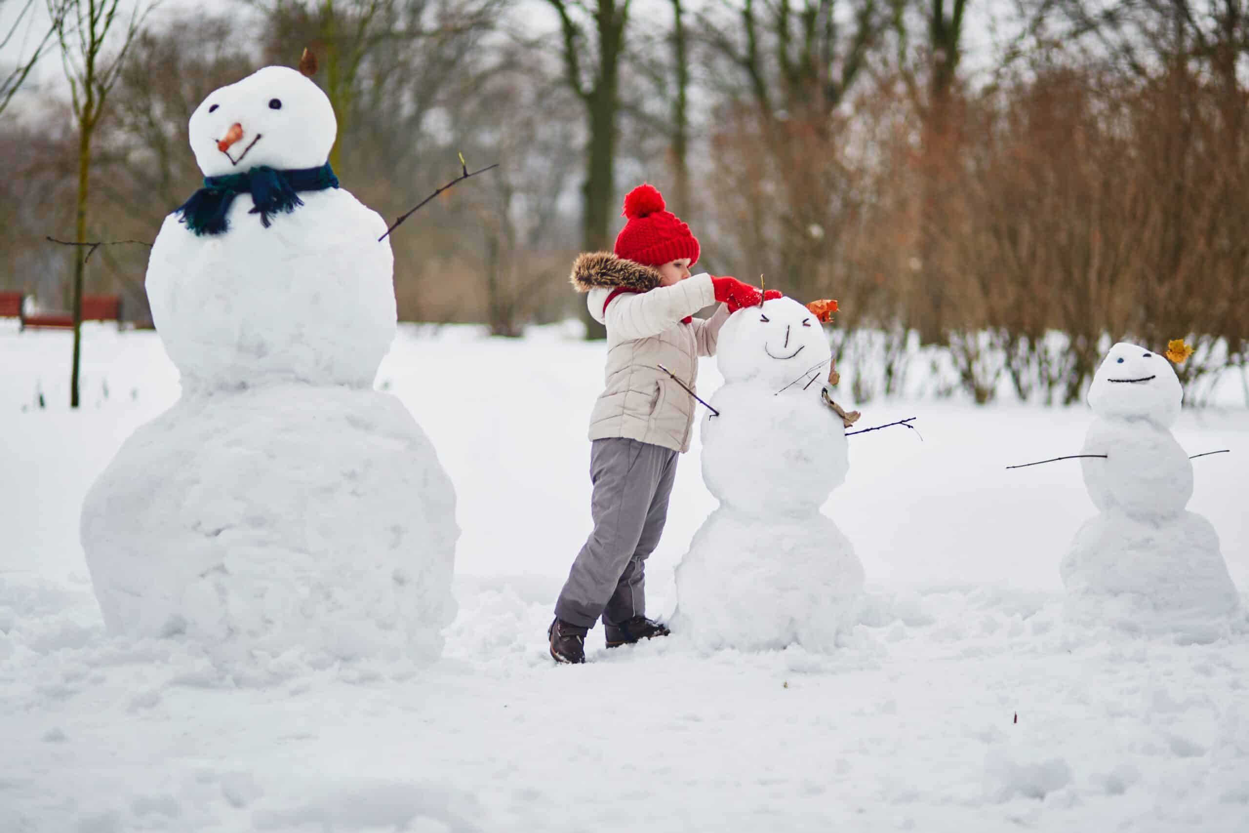 A child building a snowman outdoors