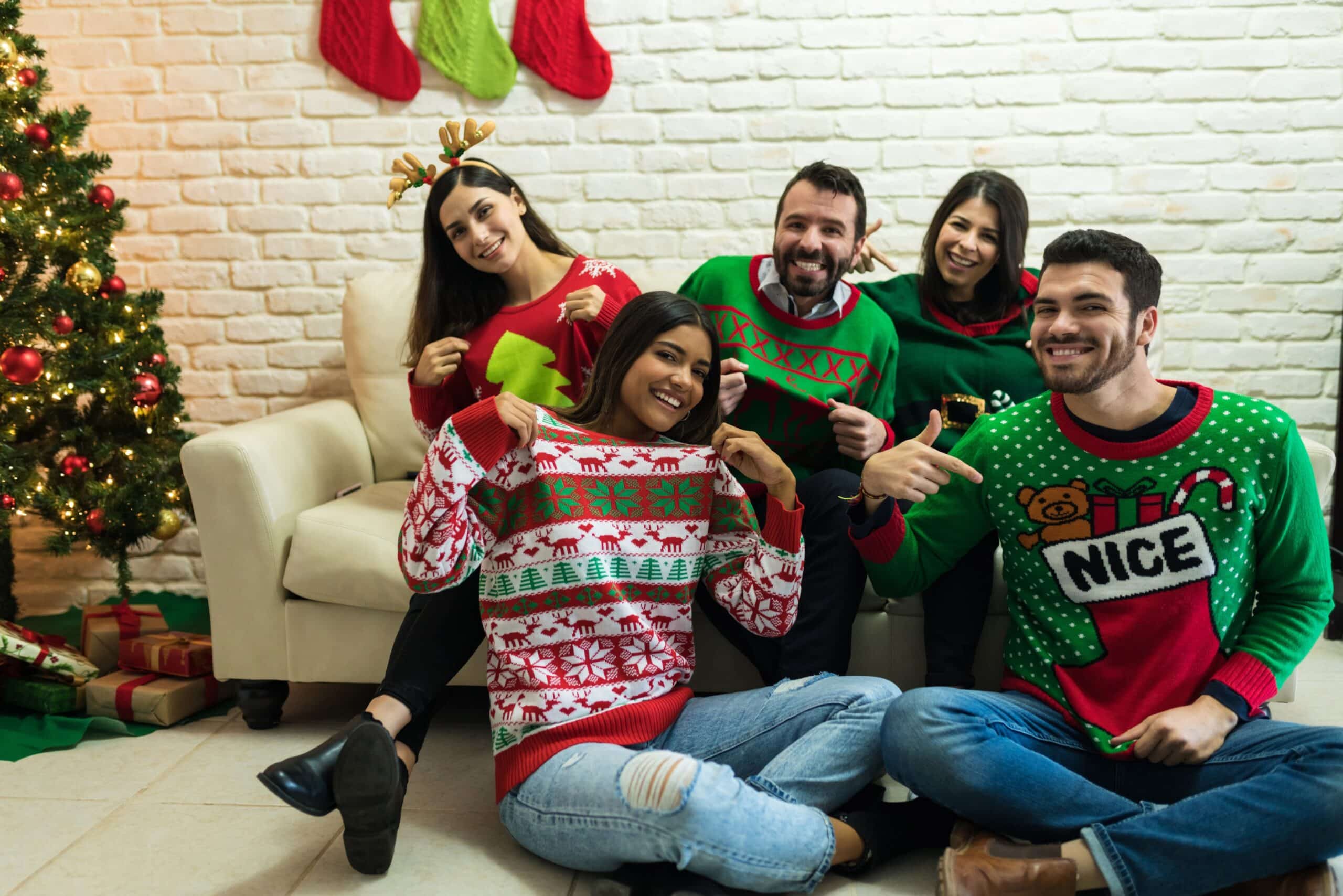 A group of friends taking a picture in their "ugly" holiday sweaters